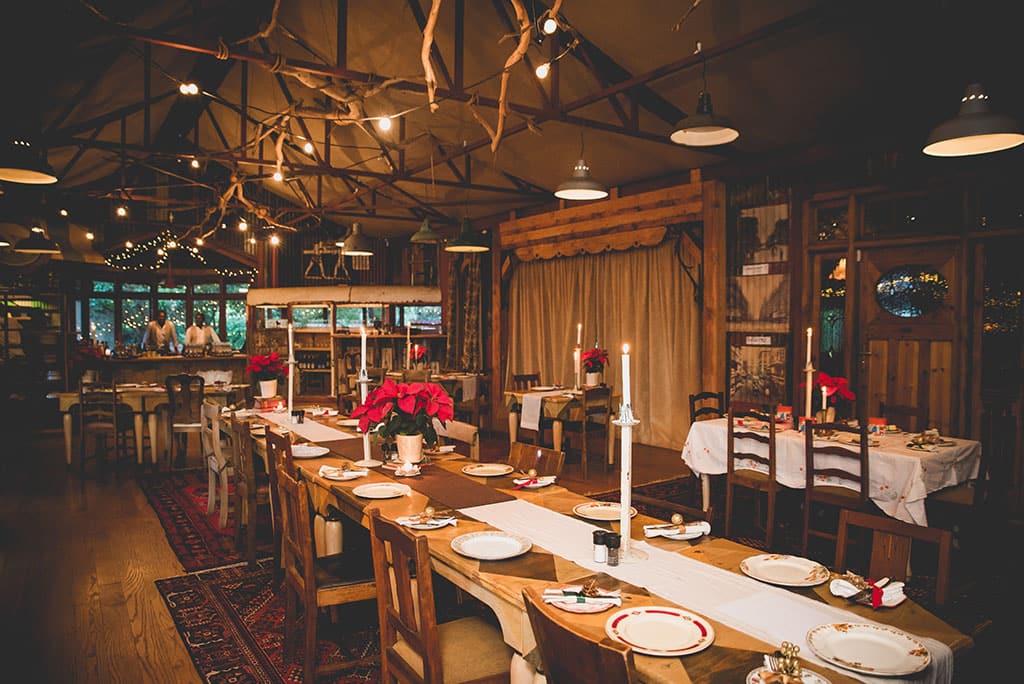 A long table laid with candles under the beamed roof