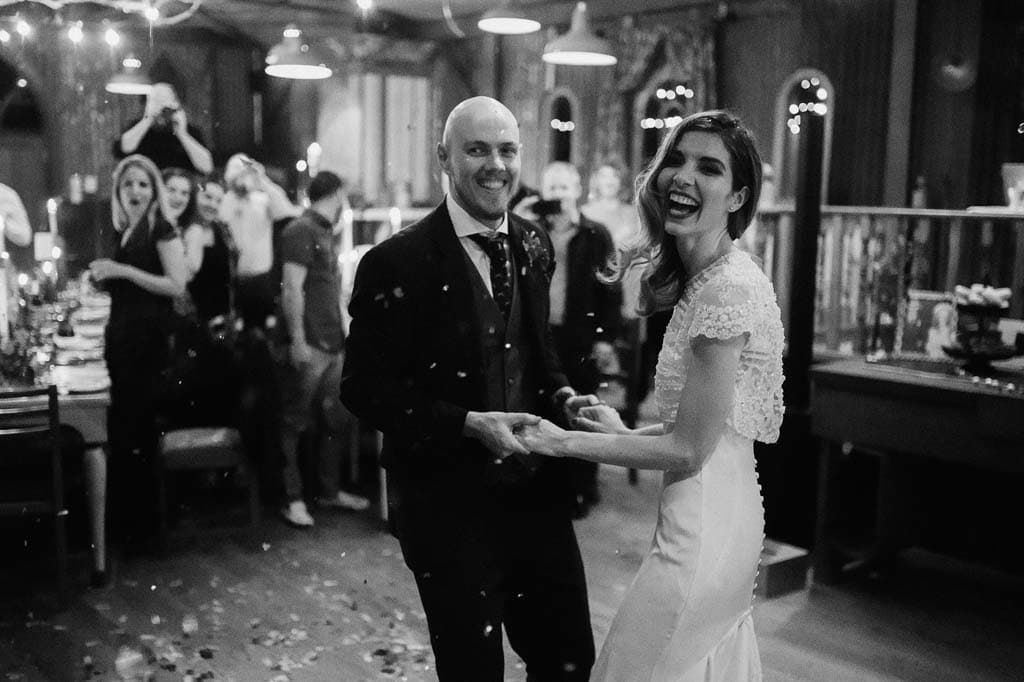 The couple dancing through confetti as their guests look on