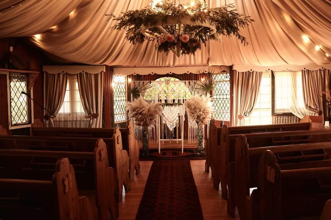 The chapel set for a ceremony, pews either side of the aisle